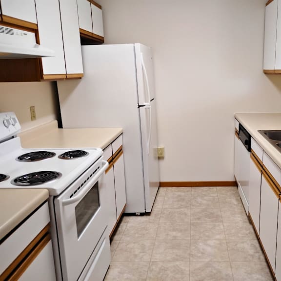 a kitchen with white appliances and brown cabinets.
