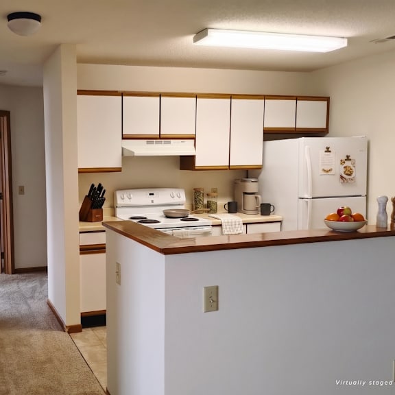 a kitchen with white cabinets and a white refrigerator.