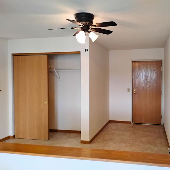 a room with a ceiling fan and two doors.