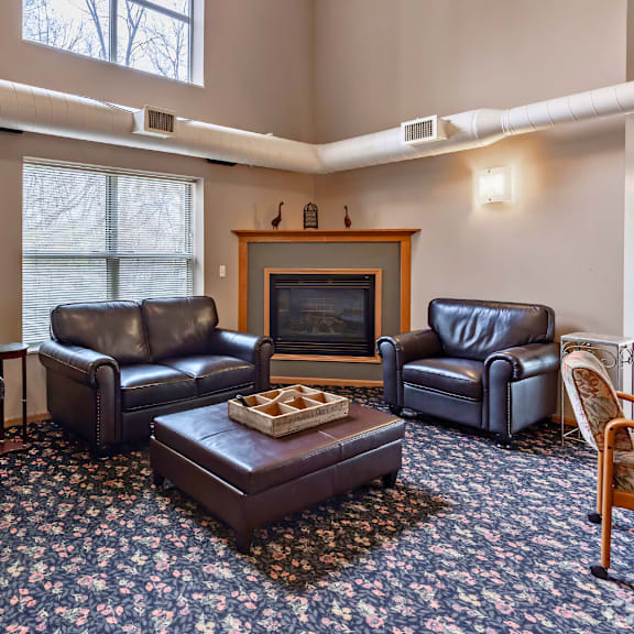 a living room with a fireplace and leather chairs.