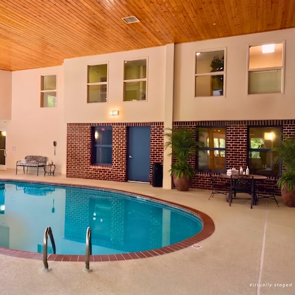 a large indoor swimming pool with a wooden ceiling and a blue door.