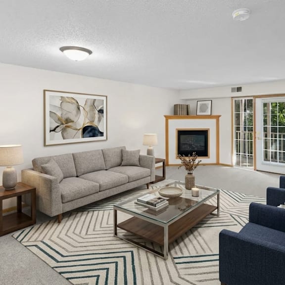 a living room with a grey couch, a coffee table, and a painting on the wall.