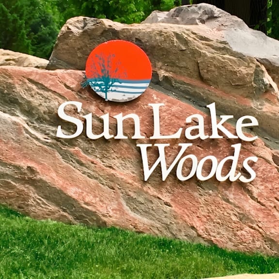 a large rock with the words sun lake woods written on it.