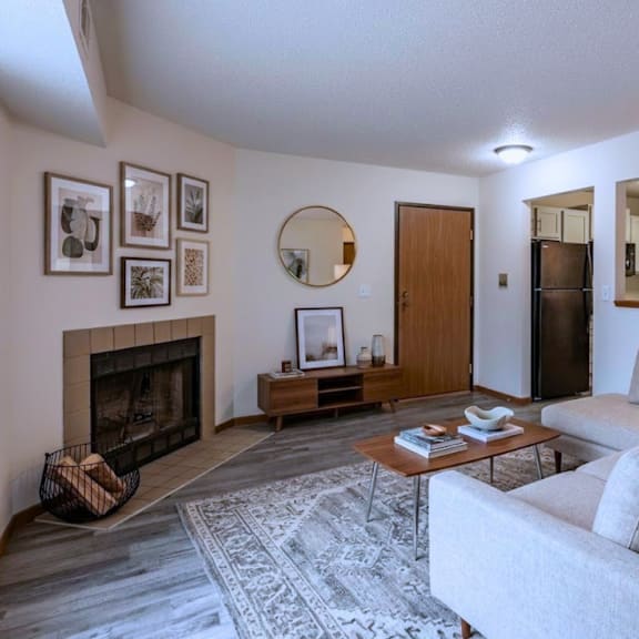 a living room with a grey couch, a fireplace, and a coffee table.