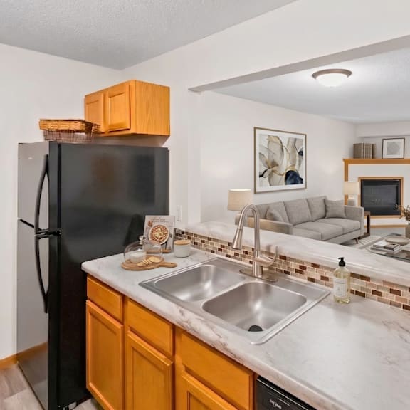 a kitchen with a black refrigerator and a marble countertop.