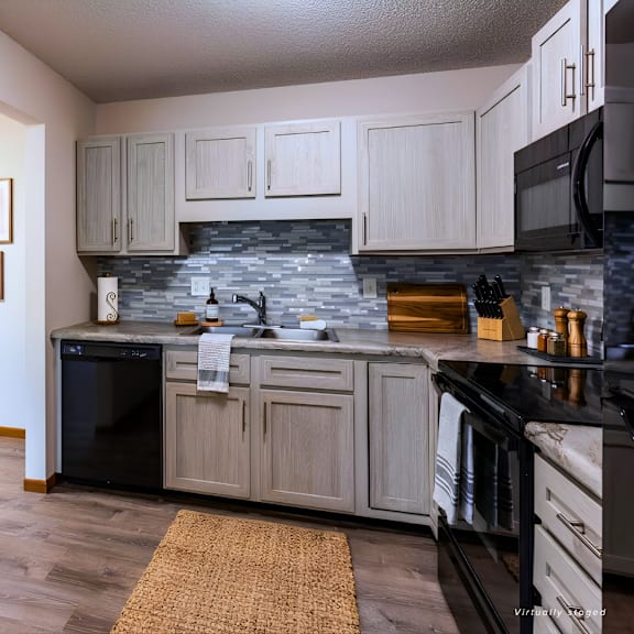 a kitchen with a black fridge and stove top oven.