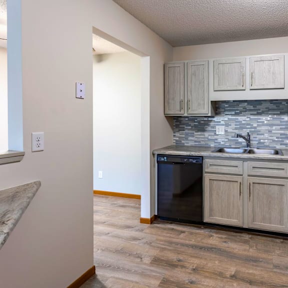 a kitchen with a black fridge, black countertops, and a black stove.