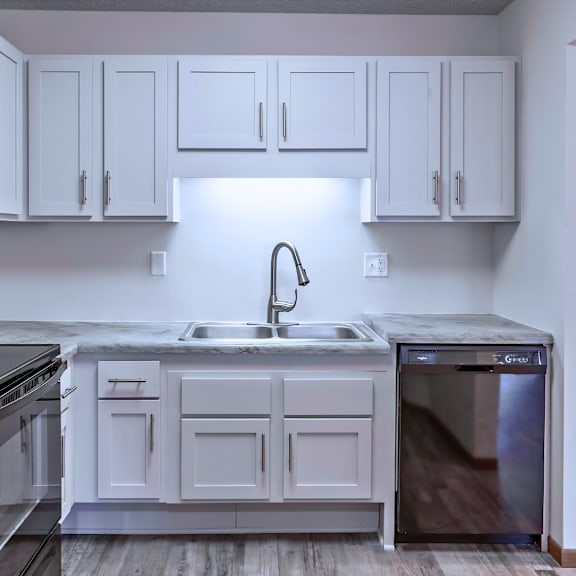 a kitchen with white cabinets and black appliances.