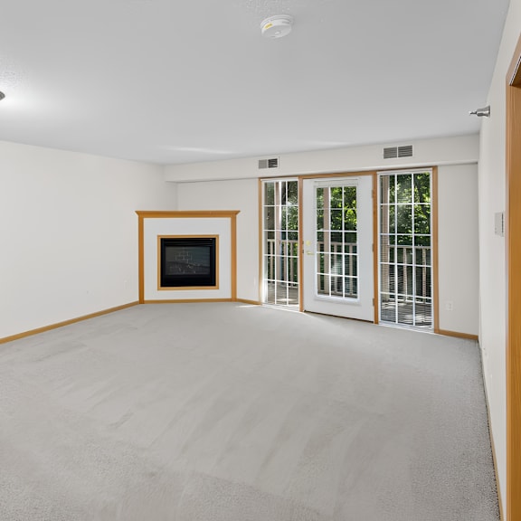 a room with a grey carpet and a television set.