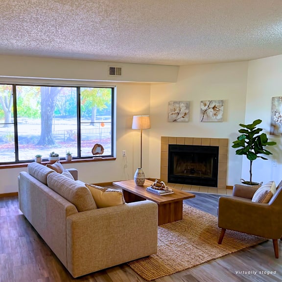a living room with a couch, a fireplace, and a large window.