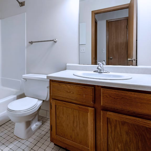 a white toilet sits in a bathroom next to a white sink.