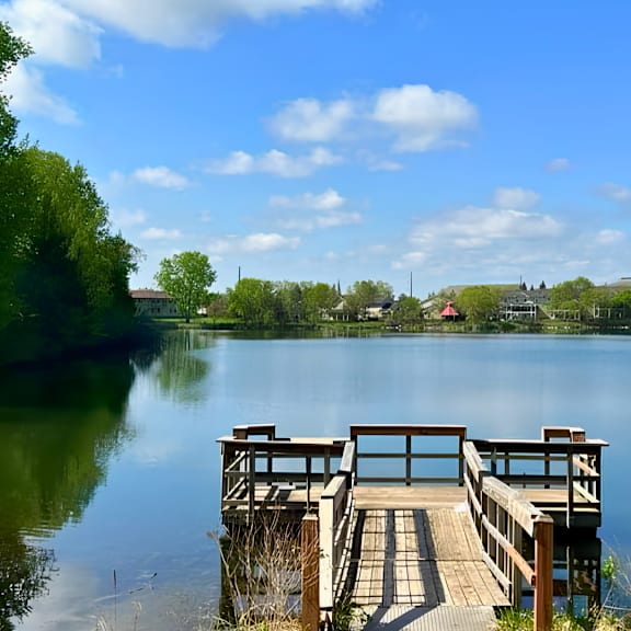 a wooden dock extends into a calm lake.