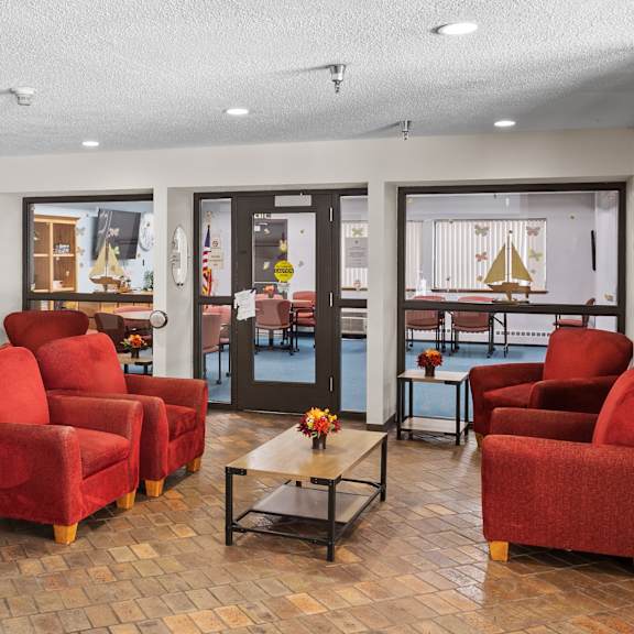 a living room with red chairs and a wooden floor.