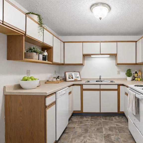 a kitchen with white appliances and wooden cabinets.