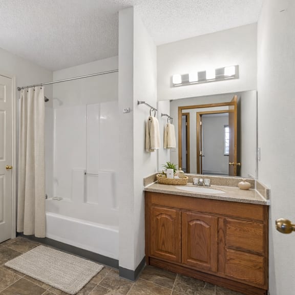 a bathroom with a toilet, sink, and shower.