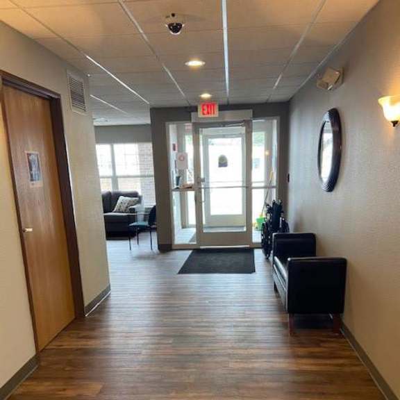 a hallway with a wooden floor and a black bench.