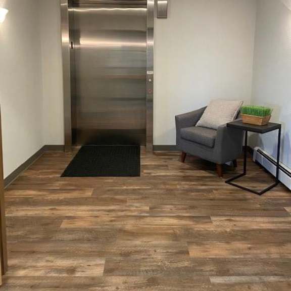 a room with a wooden floor and a metal elevator.