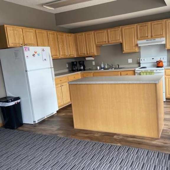 a kitchen with wooden cabinets and a white fridge.