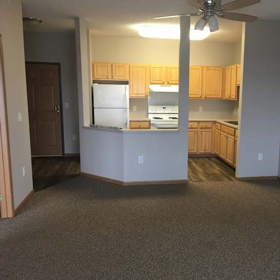 a kitchen with a refrigerator, oven, and cabinets.