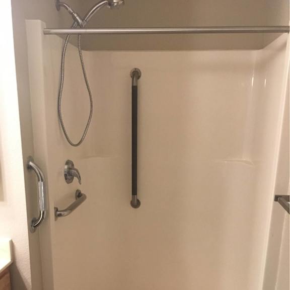 a white bathtub with a shower head and a hand held shower.