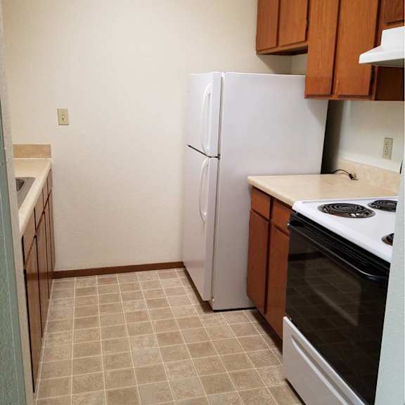 a kitchen with a white refrigerator and a white stove.