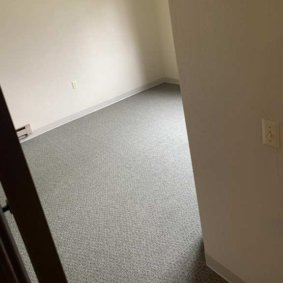 a room with a carpeted floor and a white wall.