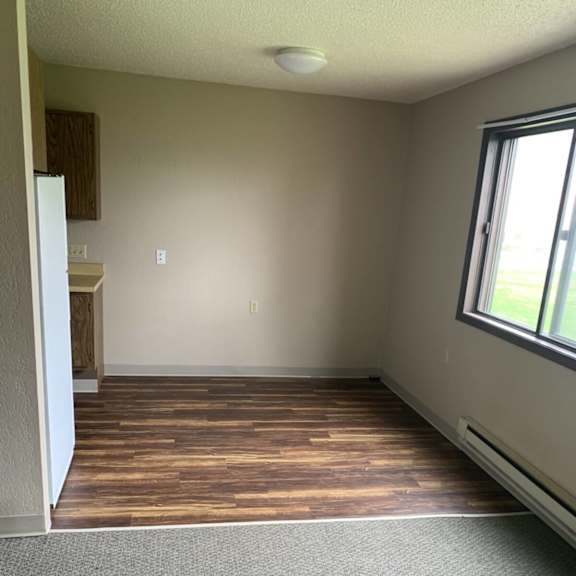 a room with a window and a wooden floor.