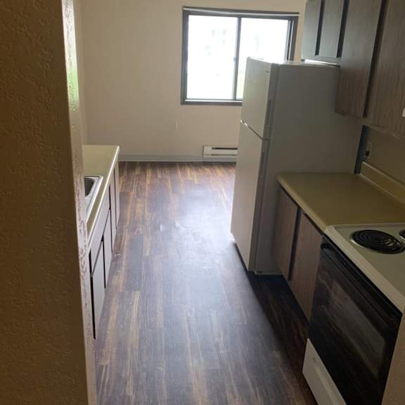 a kitchen with a white oven and wooden floors.