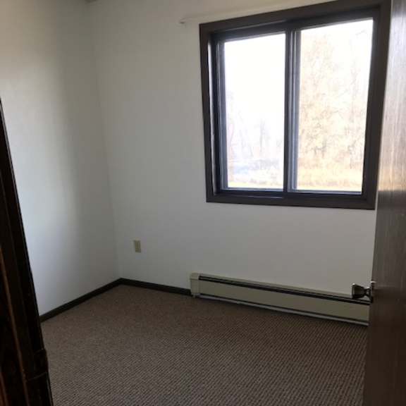 a room with a carpeted floor and a window.