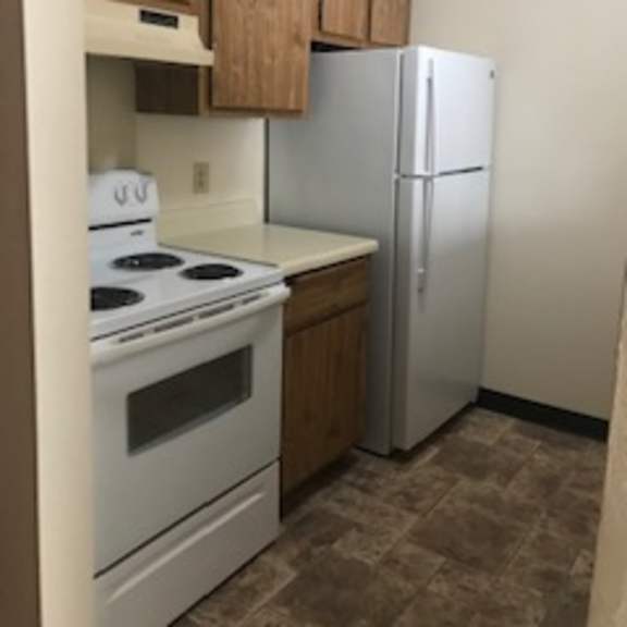 a kitchen with a white stove top oven and a white refrigerator.