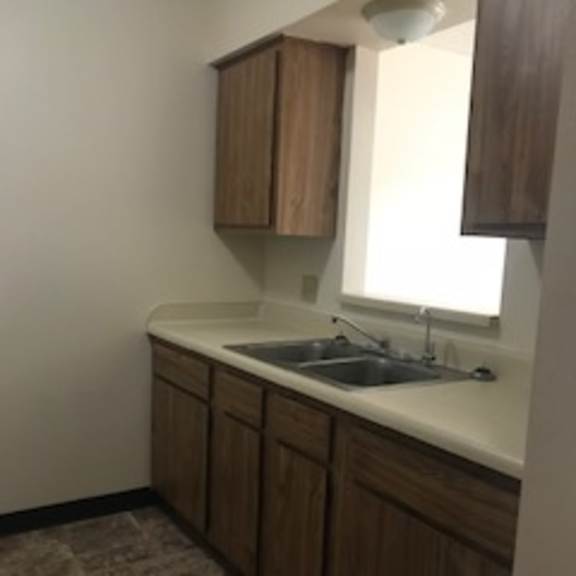 a kitchen with brown cabinets and a white counter top.