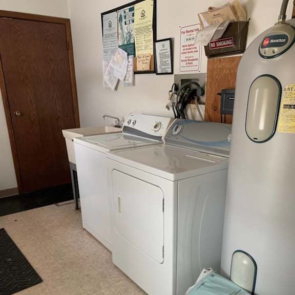 a stack of suresoft towels are on the floor next to a washing machine.