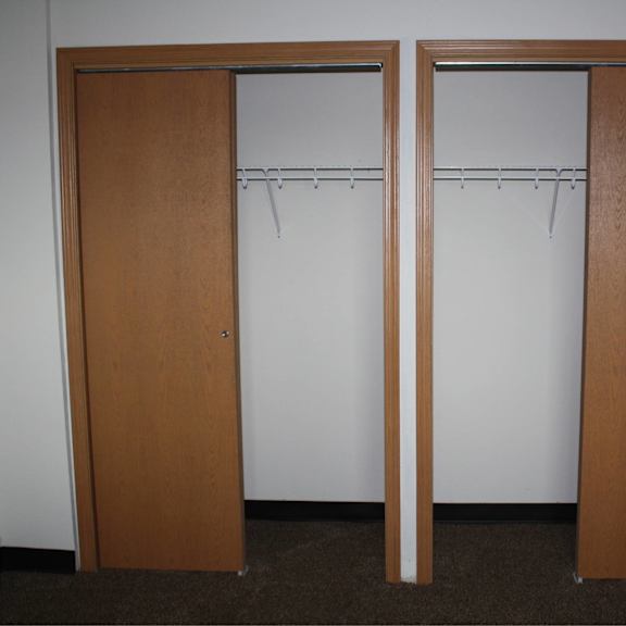 two brown doors with white walls in the background.