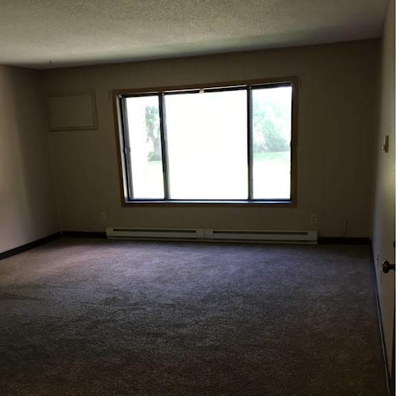 a room with a carpeted floor and a window.