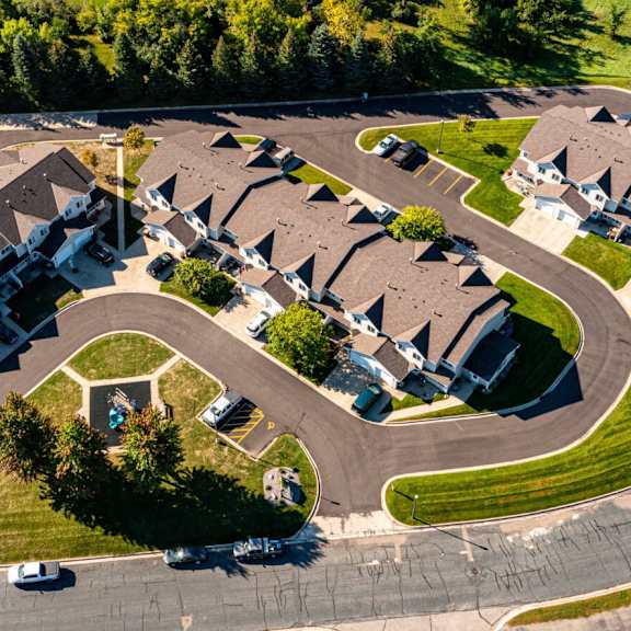 a bird's eye view of a residential area with houses and a central tree.