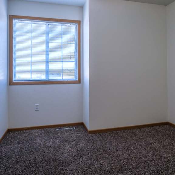 a room with a window and carpeted floor.