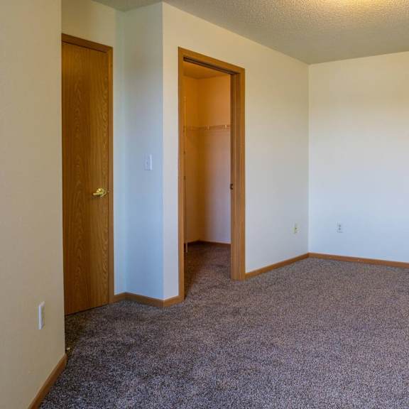 a room with a carpeted floor and two doors.