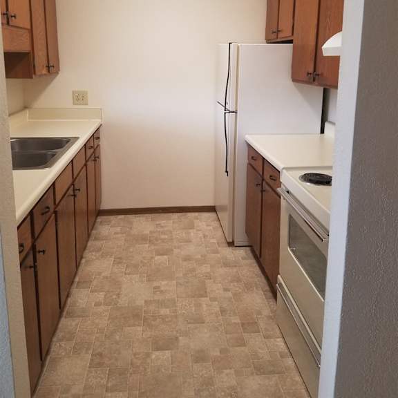 a kitchen with white appliances and brown cabinets.