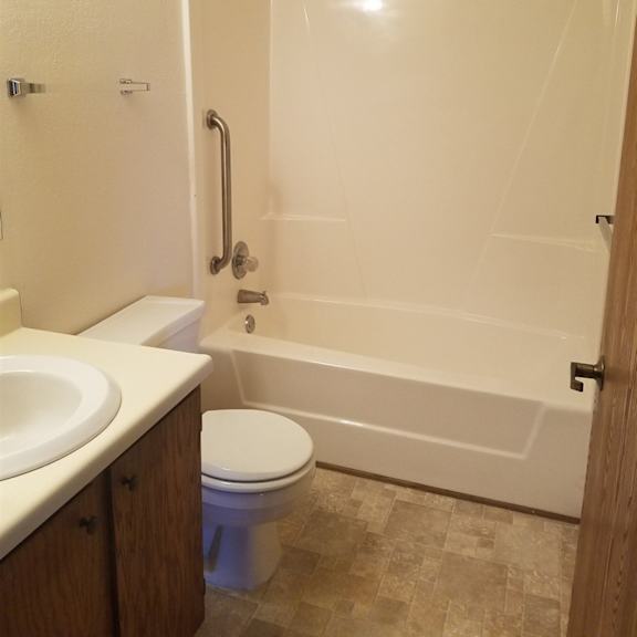 a white bathroom with a toilet, sink, and bathtub.