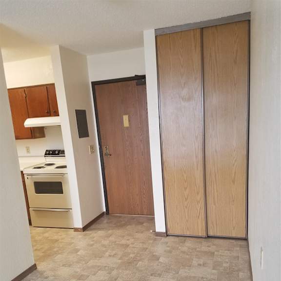 a kitchen with a tile floor and a wooden door.