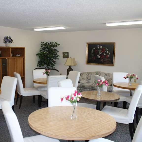 a room with white chairs and a wooden table.