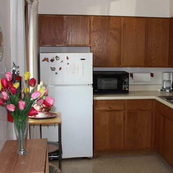 a kitchen with brown cabinets and a white fridge.