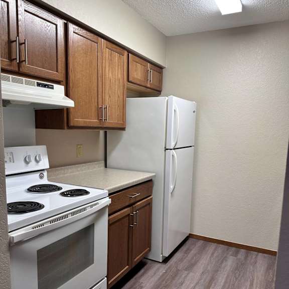 a kitchen with a white stove and a white refrigerator.