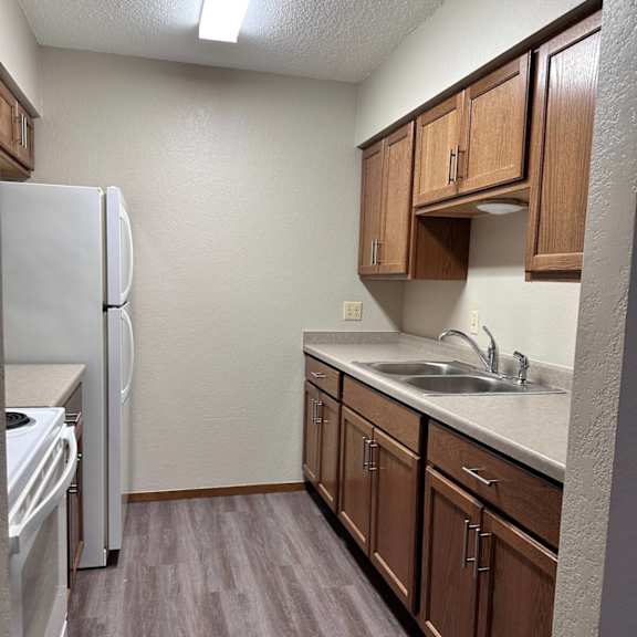 a kitchen with a white refrigerator and wooden cabinets.