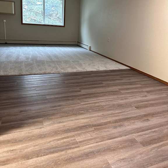 a room with a window and wooden flooring.