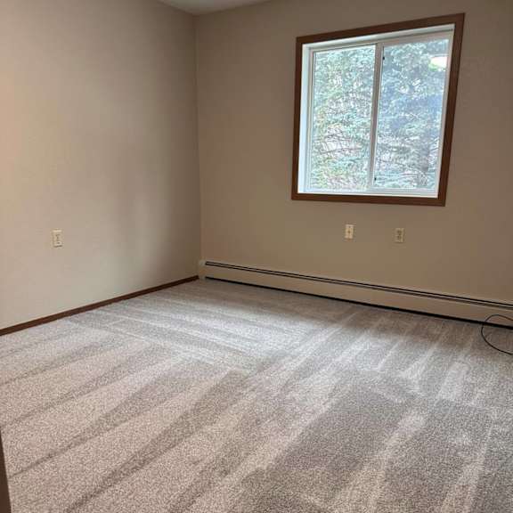 a room with a carpeted floor and a window.