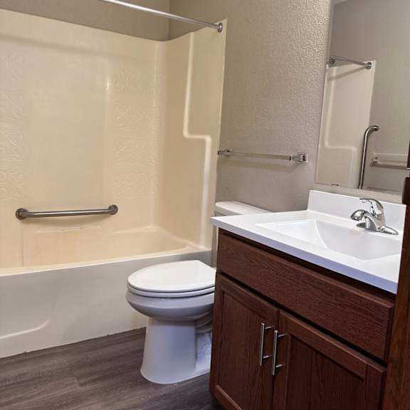 a white toilet sits in a bathroom next to a bathtub and sink.