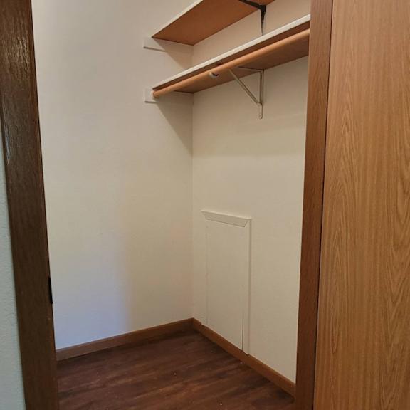 a small room with a white door and a brown floor.