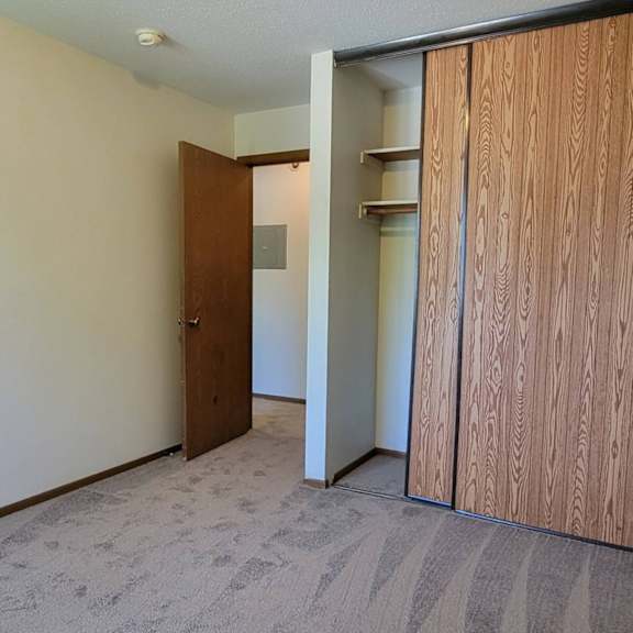 a room with a carpeted floor and a wooden door.