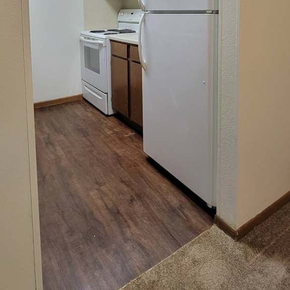 a kitchen with a white refrigerator, stove, and oven.
